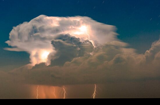 Powerful lightning illuminates dark storm clouds at night