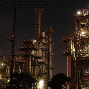 Night view of a brightly lit industrial facility showcasing intricate steel structures and machinery.