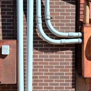 Close-up of a rusty industrial gate with a high voltage warning sign