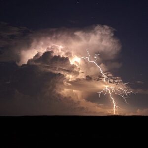 Hand of electrician working on a circuit breaker panel with colorful wires